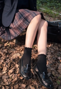 Detail of black JK style calf socks with ribbed texture and elegant ruffled lace edges