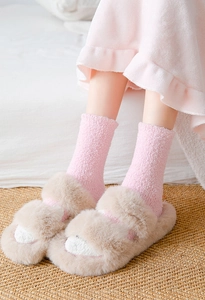 Detail von rosa Korallenfleece-Socken mit Plüschhausschuhen für gemütliche Winterwärme