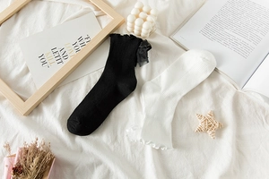 Detail showing lolita style socks with ruffled cuffs and delicate bow decorations