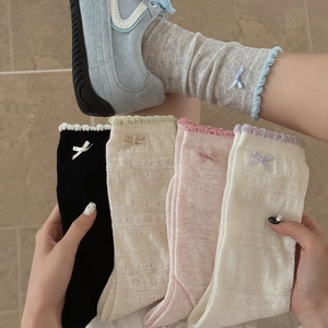 Detailed view of women's mesh lace socks with delicate bow accents and scalloped edges