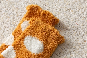 Detailed texture of thick orange and white polka dot coral fleece warm socks