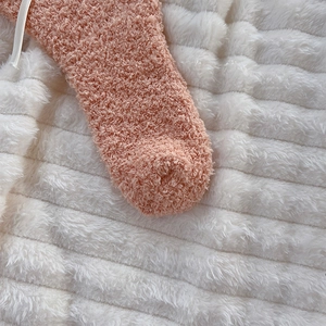 Macro shot of pink coral fleece texture on fluffy bow thermal socks for home