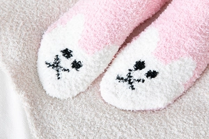 Nahaufnahme der rosa Korallenfleece-Socken mit süßer Stickerei und dicker, flauschiger Textur