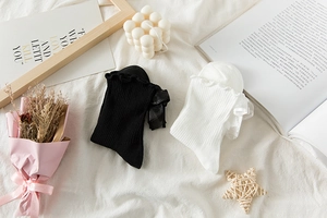Detailed view of Lolita style socks with ruffled edges and lace bow tie accents