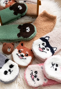 Detailansicht der weichen Korallenvlies-Wintersocken mit süßen Comic-Mustern und Plüschtextur
