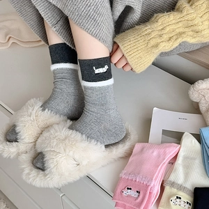 Detail of gray crew socks with plush trim, cute dog embroidery and soft ribbed knit texture