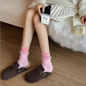 Close-up of cute cartoon dog embroidery and plush faux fur trim on mid-calf socks