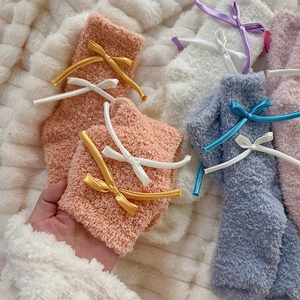 Detail of soft coral fleece socks with cute ribbon bows in warm cream and orange