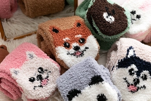 Nahaufnahme dicker Korallenfleece-Socken mit süßen 3D-Tiermustern auf weichem Plüschgrund