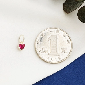 S925 sterling silver heart pendant with red zircon inlay shown next to a coin for scale