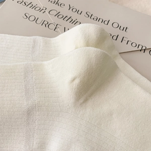 Close-up of cream-colored ribbed cotton crew socks with detailed knit texture