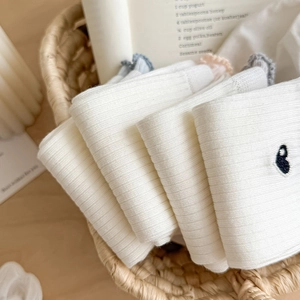 Detail of ballet style cream socks featuring ruffle edges and sweet heart embroidery