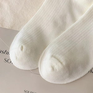 Detail of white ribbed knit cotton socks showing premium stitch texture and fabric quality