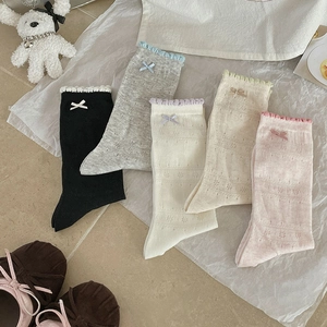 Detailed view of five pairs of pastel mesh socks with lace trim and satin bows