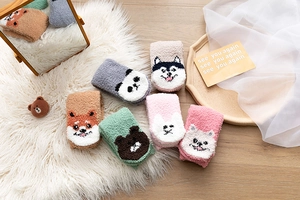 Details von bunten Korallenfleece-Socken mit niedlichen Tiergesichtern wie Pandas und Füchsen