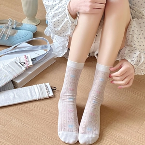 Detail of sweet mesh socks with lace edges and delicate pink and blue bow patterns