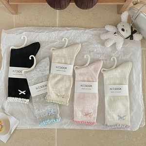 Close-up of five pairs of hollow mesh socks with lace edges and ribbon bow details