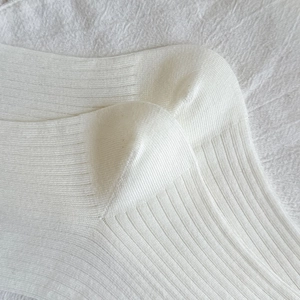 Close-up of white rib-knit socks featuring delicate vertical textures and soft cotton fabric