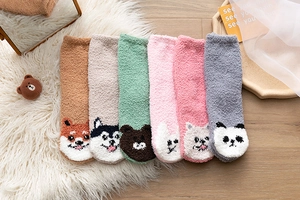 Detaillierte Flachbildansicht von sechs Paar dicken Korallenvlies-Tier-Socken auf Teppich