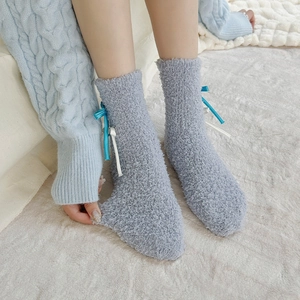 Detail of blue coral fleece socks with cute ribbon bows and soft plush texture