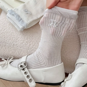 Detail of white rib socks with silver bow embroidery and ruffled cuffs with shoes