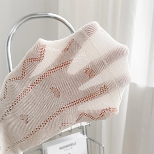 Detail der weißen Socken aus Herz-Spitzenstoff zeigt Textur und elastische Dehnung