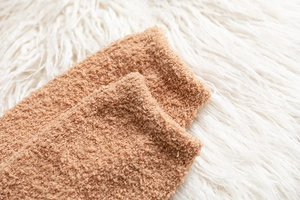Detailansicht der weichen braunen Korallenfleece-Struktur für warme Wintersocken