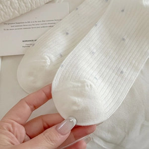 Gros plan sur des chaussettes en coton côtelé avec pois bleus et texture douce