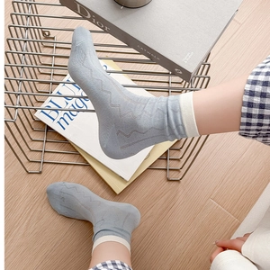 Detailaufnahme hellblauer Baumwollsocken mit Wellenmuster und weißem Rippstrick-Bündchen