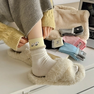 Close-up of cute dog embroidery and fluffy faux fur trim on ribbed knit cotton socks