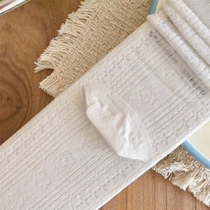 Close-up of white mesh breathable calf socks with vintage floral textures and lace trim
