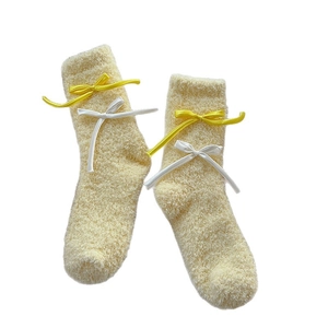 Plush cream-colored coral fleece thermal socks with decorative ribbon bows for winter