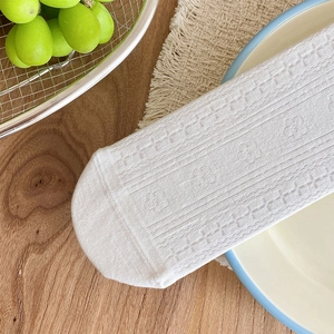 Detailed texture of white lace mesh socks with delicate floral knits on a rustic table