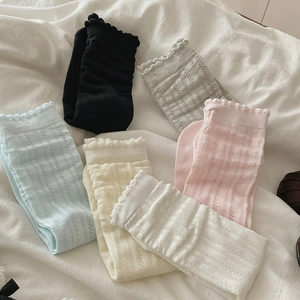 Close-up of six pastel lace-trimmed socks with hollow vertical knit texture details