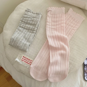 Detail of grey and pink mid-calf socks with hollow vertical stripes and wavy edges