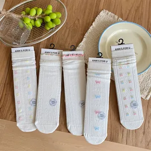 Detail of white mulberry silk socks with cherry embroidery, bows and seamless finish