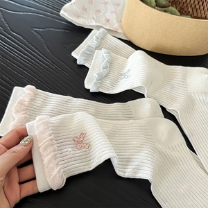Detail of sweet Lolita socks featuring ribbon embroidery and ruffled lace edges