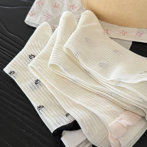 Close-up of ribbed cotton Lolita socks featuring cute bows and pink ruffle edges