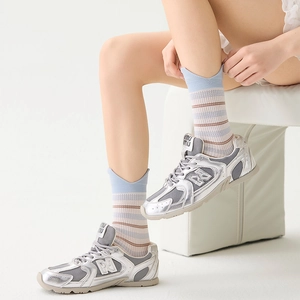 Detail of silver metallic leather sneakers paired with light blue striped knit crew socks
