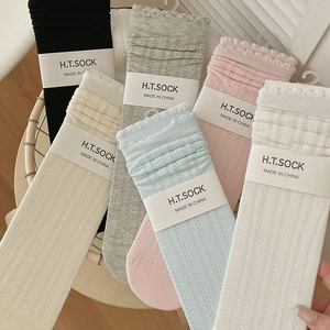 Detail of ruffle trim and hollow wave texture on colorful pastel mid-calf socks