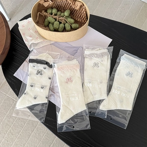 Detail of four pairs of ribbed cotton socks with lace trim and colorful 3D bows