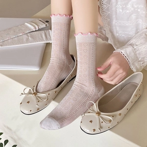 Detail view of heart mesh socks with ruffle edges and bow loafers for a sweet JK style