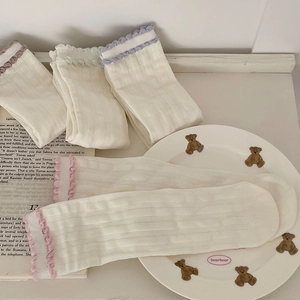 Detail of white ribbed socks with colorful ruffled trim and soft cotton texture