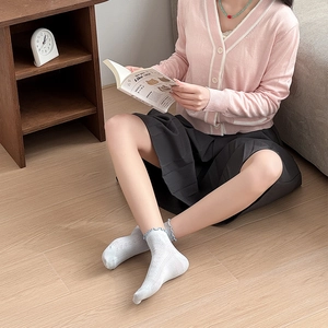 Detail showing women's low-cut mesh socks with heart cutouts and ruffled blue edges