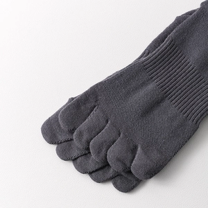 Detail shot of grey five-toe socks showing fine knit texture and split toe design