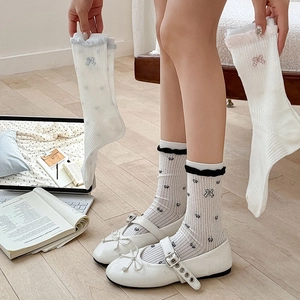 Detail of white Lolita style crew socks featuring delicate lace trim and tiny bows
