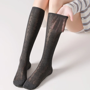 Detail of black lace jacquard mid-calf socks with breathable semi-sheer floral pattern