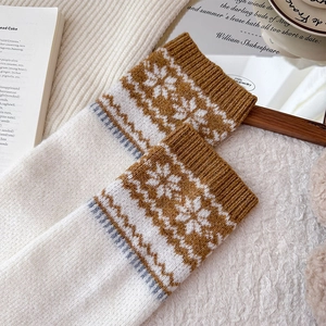 Detailed knit texture of Nordic snowflake pattern leg warmers on cozy winter background