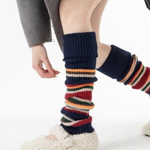Detail of vintage striped knit leg warmers with thick ribbed texture and mary jane shoes