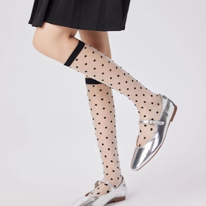Sheer polka dot knee-high socks for women paired with silver Mary Jane shoes